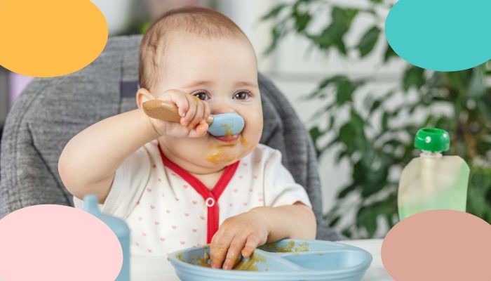 bebé iniciando alimentación complementaria con comida sólida en trona